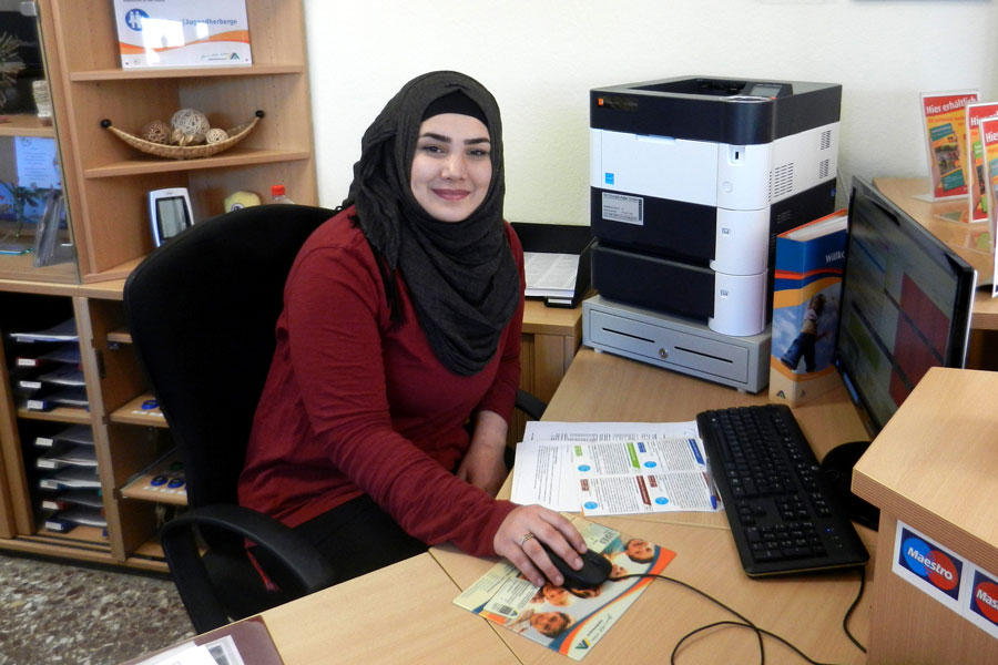 Eine junge Syrerin an ihrem Arbeitsplatz im Büro.